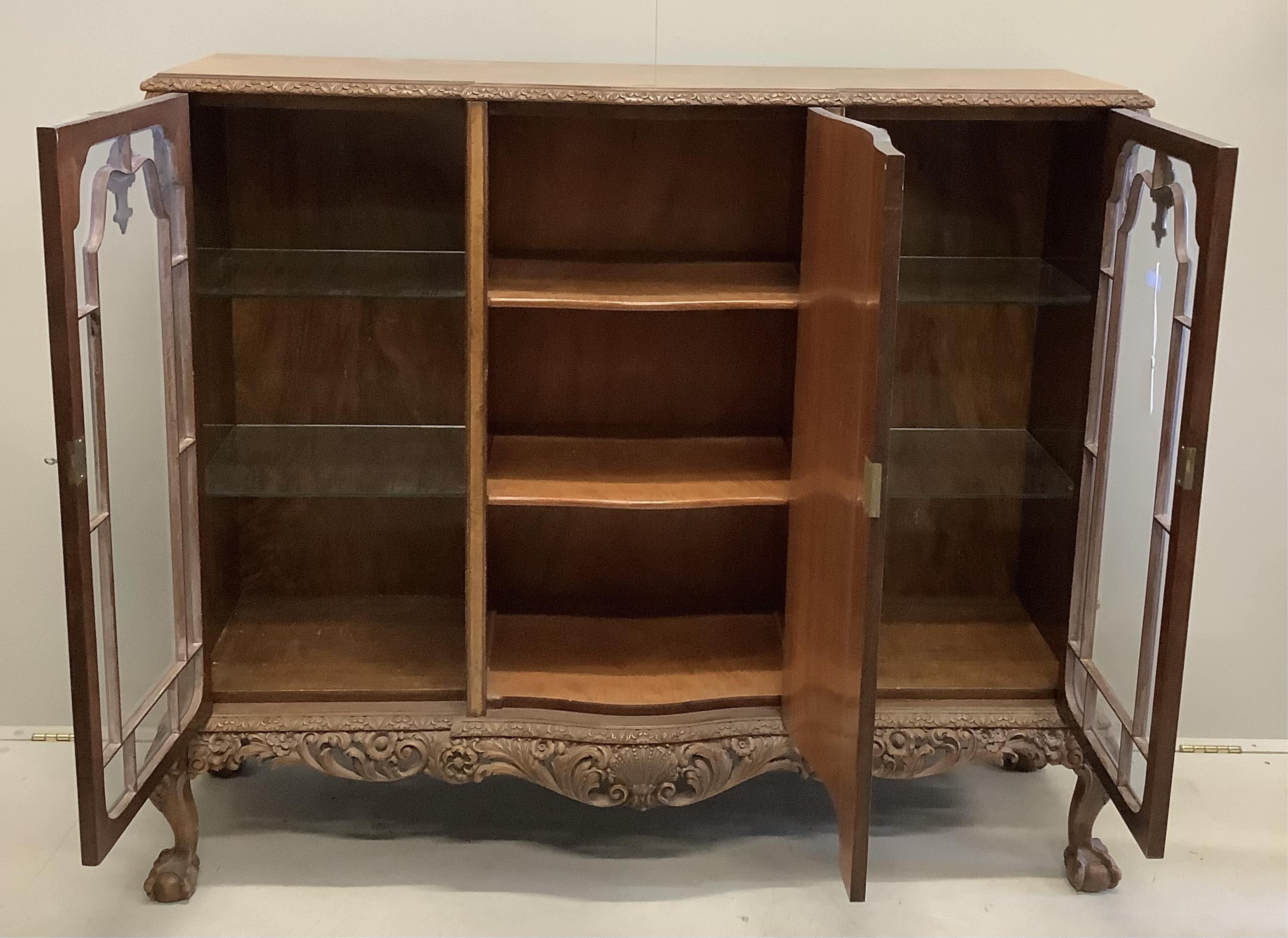 A Queen Anne revival walnut bookcase cupboard, width 136cm, depth 40cm, height 121cm